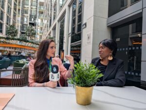 Two She’s In Business women business owners holding a She’s In Business microphone, representing confident leadership, peer support, and women-led entrepreneurship within the accelerator community.